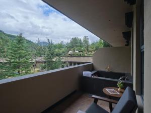 un balcon avec une table et des chaises et une vue dans l'établissement Jiuzhaigou Valley Scenic and Historic Interest Area Stargazing · Vacilando Resort, à Tazang 92 autres photos