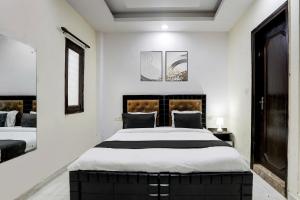 Un dormitorio con una cama grande y dos ventanas. en Hotel O Metro Residency, en Nueva Delhi 25 fotos más