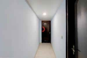 a hallway with a door and a tile floor at Hotel O Metro Residency in New Delhi