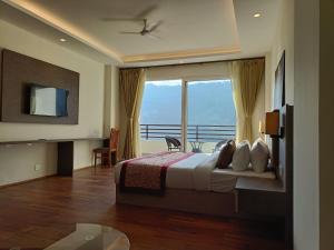 a bedroom with a bed and a large window at Zambala residency & spa in Gangtok