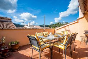 een terras met een tafel en stoelen op een balkon bij Maison Collo in Collobrières