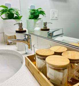 a bathroom with a sink and a tray of jars at The SuiteLife, Calgary in Calgary