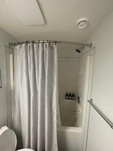 a bathroom with a shower curtain and a toilet at The SuiteLife, Calgary in Calgary +21 photos
