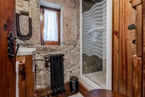 un bagno in pietra con lavandino e doccia di Casa do Gerês a Geres Altre 27 foto
