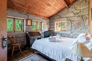 una camera da letto con un letto in una stanza di pietra di Casa do Gerês a Geres
