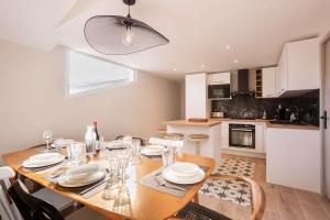 a dining room with a table and a kitchen at Magnifique Appartement Biscarrosse Bourg in Biscarrosse