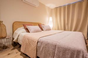 a bedroom with a bed with white sheets and pillows at Magnifique Appartement Biscarrosse Bourg in Biscarrosse