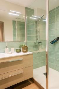 a bathroom with a glass shower and a sink at Magnifique Appartement Biscarrosse Bourg in Biscarrosse