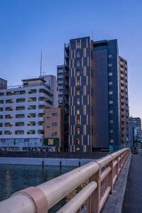 大阪Namba River Side Garden Hotel的水体旁高楼城市
