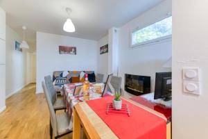 ein Wohnzimmer mit einem Tisch und einem Sofa in der Unterkunft Vacances de rêves - Amoureux in Chamrousse