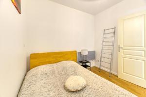 ein Schlafzimmer mit einem Bett mit einem hölzernen Kopfteil in der Unterkunft Vacances de rêves - Amoureux in Chamrousse