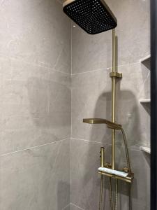 a shower with a shower head in a bathroom at Nest One Luxe, Элитные апартаменты с балконом и видом на фонтан Tashkent City Park 110 in Tashkent