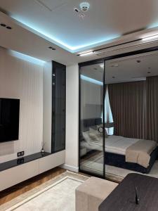 a bedroom with a bed and a tv in it at Nest One Luxe, Элитные апартаменты с балконом и видом на фонтан Tashkent City Park 110 in Tashkent