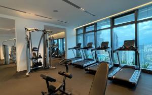 a gym with a bunch of treadmills and machines at Ikon Service Residence at Eaton in Kuala Lumpur