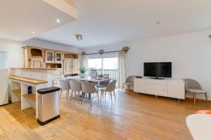 eine Küche und ein Wohnzimmer mit Tisch und Stühlen in der Unterkunft Vacances de rêves - Gaboureaux in Chamrousse