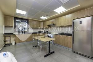 a kitchen with a table and a refrigerator at Bloomfields Luxurious 2BR Maid Room in Fujairah