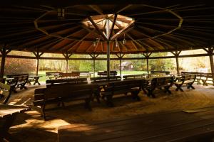 a group of wooden benches under a large umbrella at Radocza Park Active & Spa in Radocza +20 photos