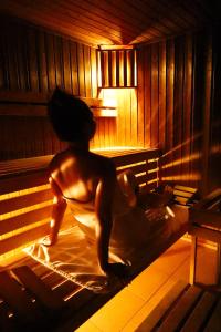 a man sitting on a bed in a sauna at Radocza Park Active & Spa in Radocza