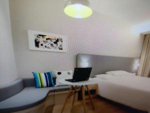 BahādrābādにあるHotel Shivのベッド1台、ノートパソコン1台(デスク内)が備わります。