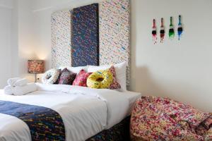 a bedroom with two beds with colorful pillows at Bangkok River Loka Hotel in Bangkok