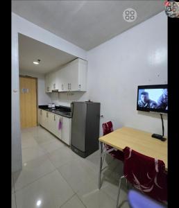 a kitchen with a table and a tv on the wall at FinkSea @ Sea Residences in Manila +27 photos