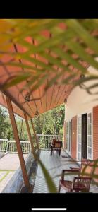 a patio with chairs and a table under a umbrella at The VARANDAH LOUNGE in Vagamon
