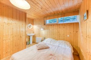 a bedroom with a bed in a wooden wall at Vacances de rêves - Casserousse in Chamrousse