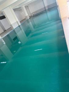 a swimming pool with green water in a building at Furnished two bedroom apartment with swimming pool fully equipped gym children playground ample parking space and unbeatable scenic city views in Nairobi