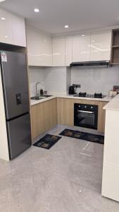 a kitchen with a refrigerator and a sink at Furnished two bedroom apartment with swimming pool fully equipped gym children playground ample parking space and unbeatable scenic city views in Nairobi