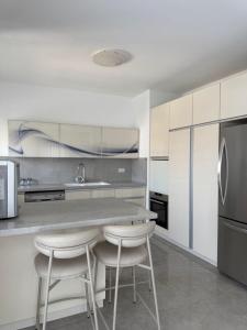 a kitchen with a counter and stools in it at צליל ההר - The sounds of the mountain in Safed
