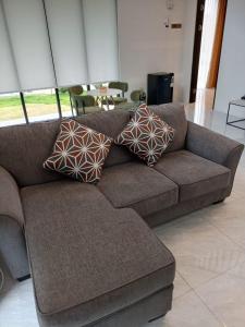 a brown couch with pillows on it in a living room at Wind Hill Mountain View Resort in Gununggeulis