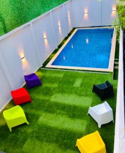 Una vista aérea de una piscina con sillas de colores. en Résidence touristique marcadal, en Fort de lʼEau