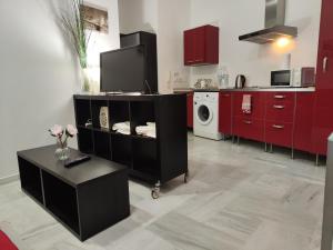 a kitchen with red cabinets and a washer and dryer at jp7 Piso y parking 10min Sevilla - Zona Comercial - Joyeria - Pescaderia in Camas