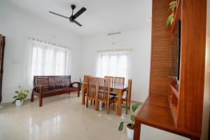 a living room with chairs and a ceiling fan at Breathe homestay in Ambalavayal