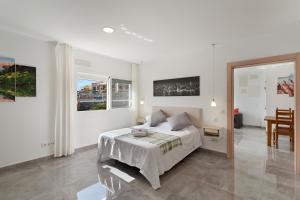 a white bedroom with a bed and a table at Modern Loft Las Palmas views 2 suit in Ciudad Jardín