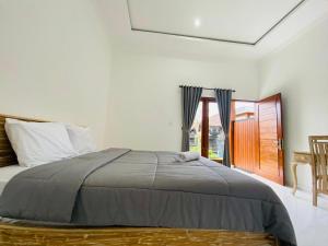 巴东Lumbung Guesthouse Canggu的一间卧室，里面有一张床和一扇窗户。