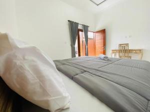 巴东Lumbung Guesthouse Canggu的卧室里有一张床，床上有一个枕头