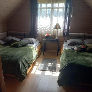 a bedroom with two beds and a table with a lamp at Jaundzelves in Stacija )) (( Ozoli +46 photos