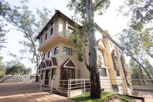 パンチガニにあるGreen Paradise Hotel and Restaurantの前に木がある建物