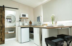 a kitchen with a table and a counter with chairs at Karoo Stop Guesthouse in De Aar