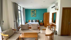 a living room with a table and a bed at Golden Rose Hotel in Con Dao +13 photos