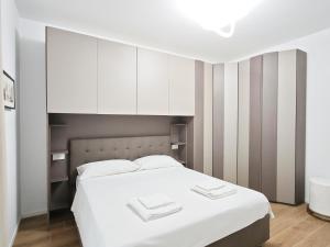 a bedroom with a white bed and white cabinets at Costa del Sole in Bari