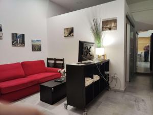 a living room with a red couch and a table at jp7 Piso y parking 10min Sevilla - Zona Comercial - Joyeria - Pescaderia in Camas