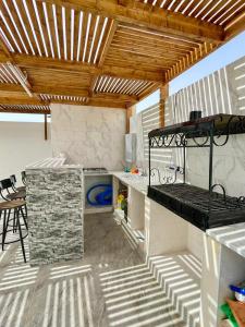 a kitchen with a grill and a table and chairs at Dar kenza in Ouled Yaneg +15 photos