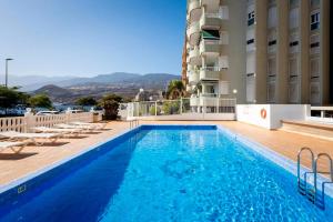 a large blue swimming pool next to a building at Paraíso Atlántico in Radazul