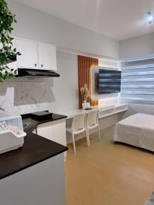 - une chambre avec un lit et un bureau avec des chaises dans l'établissement AACozyStays, à Cagayán de Oro