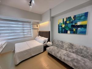 - un salon avec un canapé et un tableau dans l'établissement AACozyStays, à Cagayán de Oro 13 autres photos