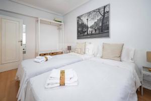 two beds in a room with white sheets at Clave Norte By Silastur in Gijón