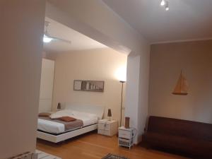 una camera da letto bianca con un letto e un divano di Relais b& Le Rondinelle a Rosignano Solvay