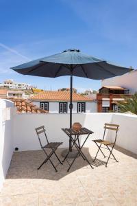 a table and two chairs under an umbrella on a roof at CHC - Casa La Salvada - Los Silos in Los Silos